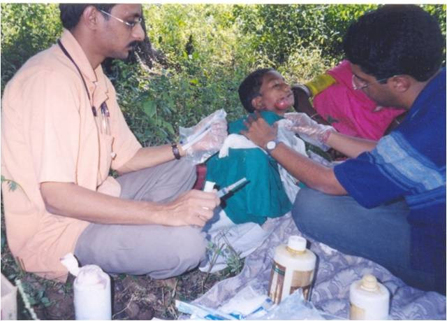 Speciality Camp-Ear, Nose & Throat Surgeon treating child patient in field