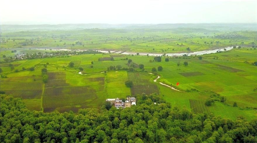Aerial view of the MAHAN campus among green fields and forest